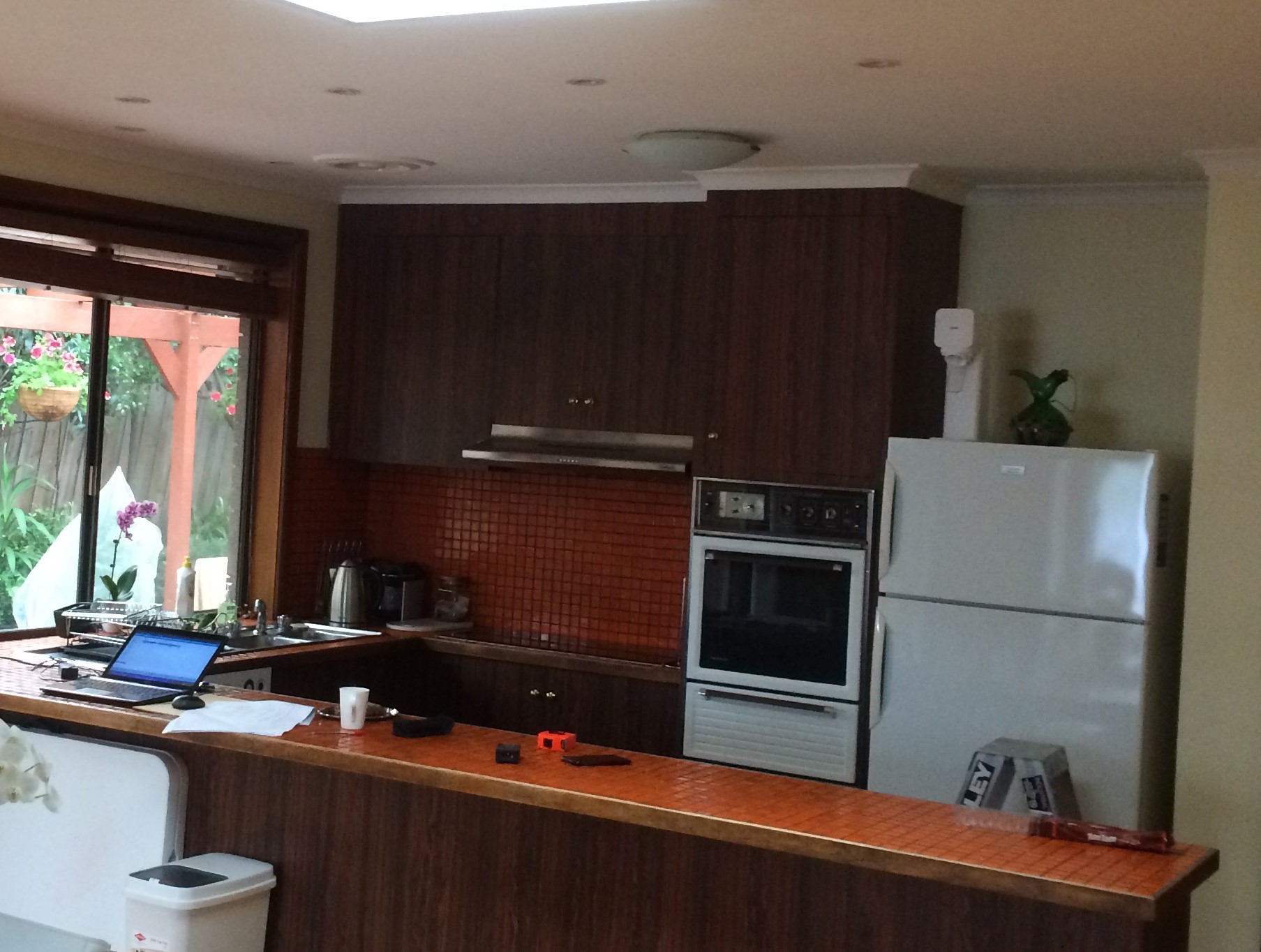 Read more about the article Orange Tiles and Mission Brown cabinets