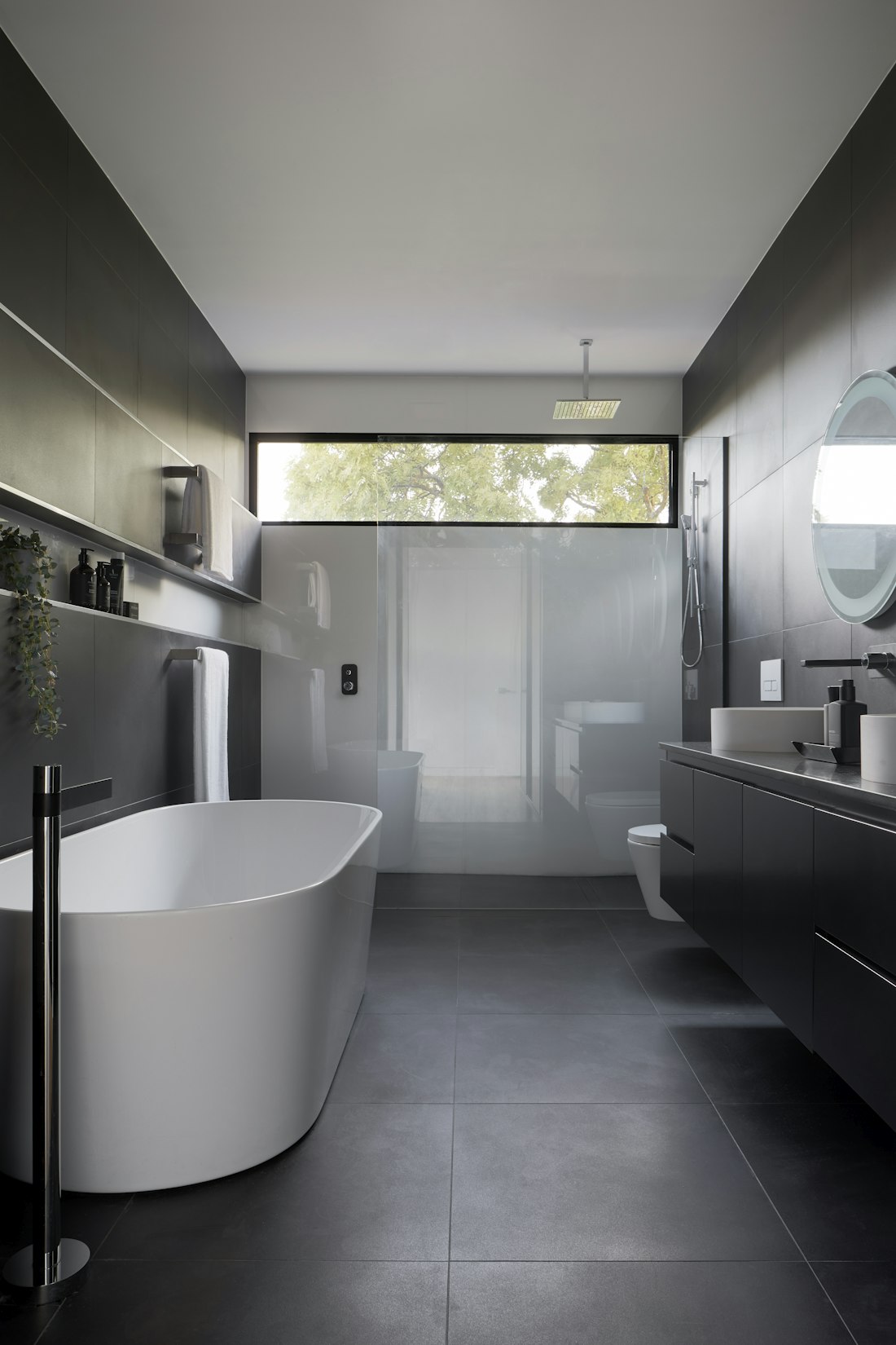 Contemporary Melbourne bathroom design featuring warm timber vanity, terrazzo flooring, matte black tapware, and natural stone benchtop